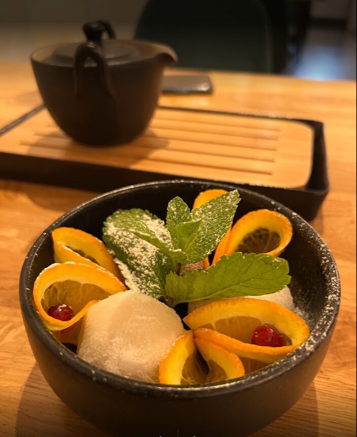 Feines veganes Mochi-Dessert mit Orangen und Minze dekoriert